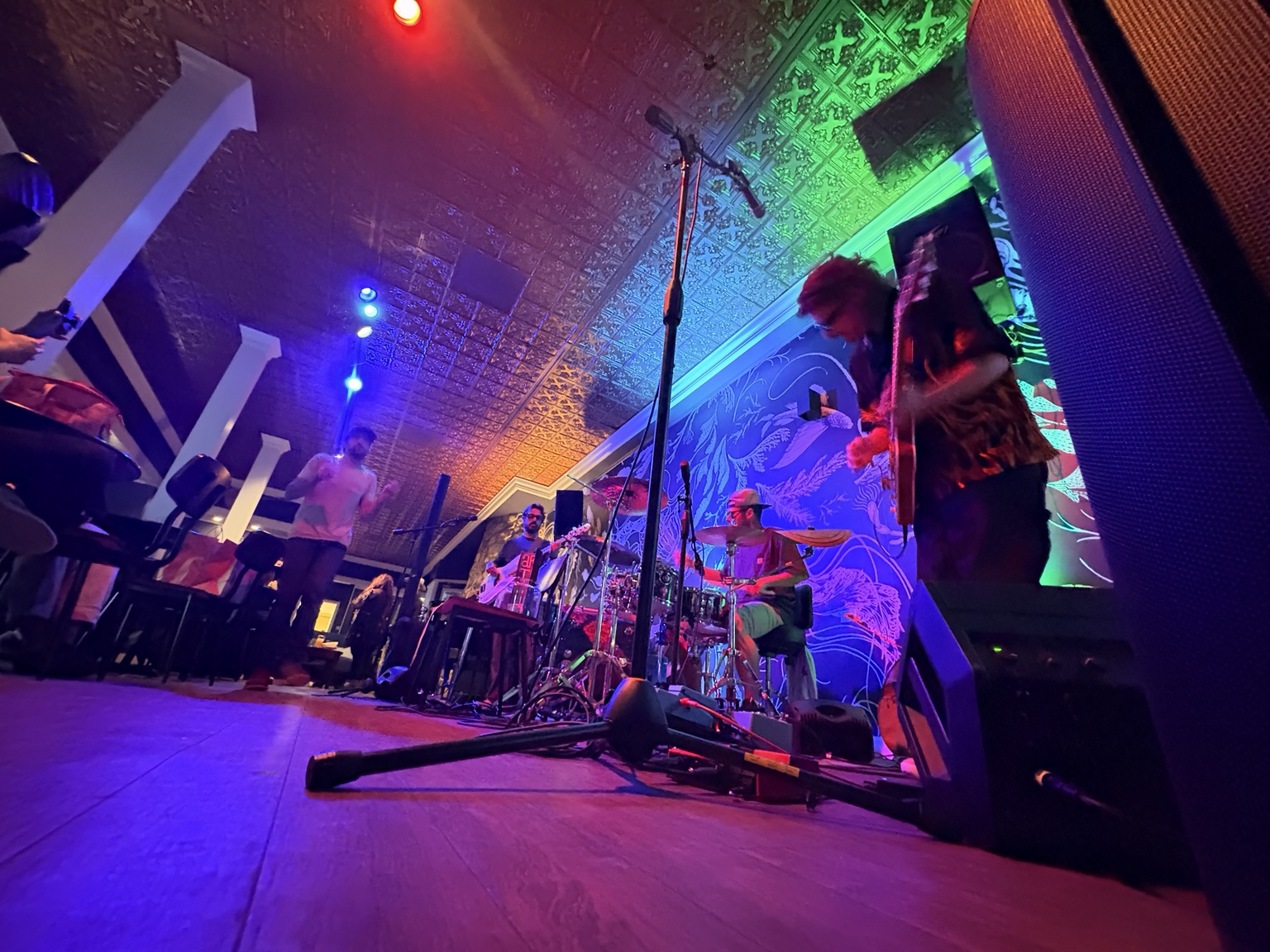 Phill’s Blues Band performing under colorful lights inside the PG Meetinghouse